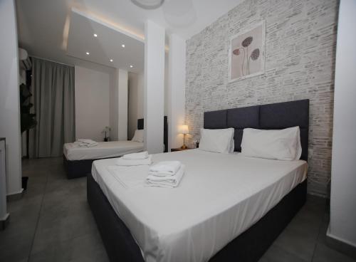 a bedroom with two beds and a brick wall at Sophia seaview suites & restaurant in Nea Vrasna