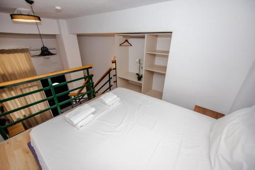 a white bed in a room with a balcony at Sophia seaview suites & restaurant in Nea Vrasna