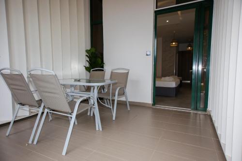 a table and chairs on a porch with a table and a door at Sophia seaview suites & restaurant in Nea Vrasna