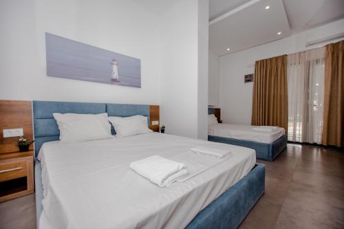 a bedroom with a large white bed with a lighthouse on the wall at Sophia seaview suites & restaurant in Nea Vrasna