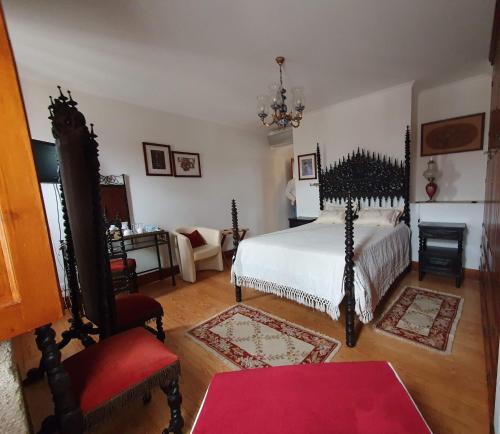 Solar Quinta de São Carlos في فيزيو: غرفة نوم بسرير ابيض وكرسي