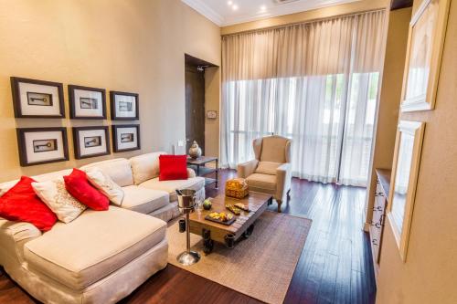 a living room with a white couch and red pillows at Bastión Luxury Hotel in Cartagena de Indias
