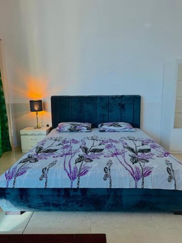 a bedroom with a bed with a purple comforter at Lux Living Room in Ajman