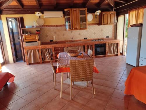 een keuken met een tafel en stoelen in een kamer bij villa da sogno in vetro in Castellammare del Golfo