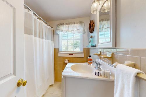 a bathroom with a sink and a shower curtain at Far Away by the Sea in Yarmouth