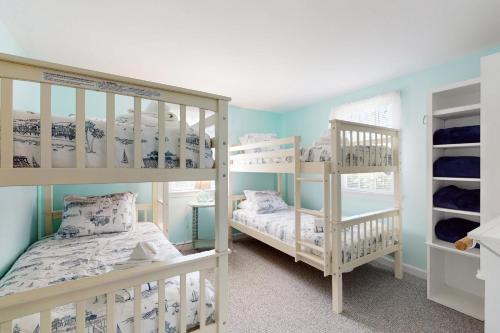 two bunk beds in a room with blue walls at Far Away by the Sea in Yarmouth