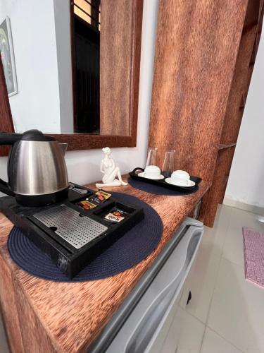 a kitchen counter with a coffee pot and glasses on it at Nungwi Beach Front in Nungwi