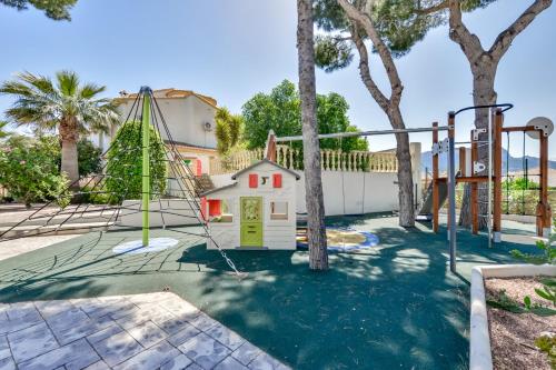 a playground with a pretend house and a swing at Villa FORTUNA - Apartamentos у Estudios para vacaciones con territorio y piscina común, Calpe in Calpe