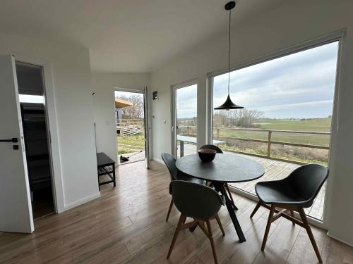 a dining room with a table and chairs and a large window at Cozy Tiny House In Nature - Holiday Home D in Sejerby