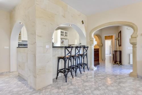 a kitchen with arches and a bar with stools at Villa FORTUNA - Apartamentos у Estudios para vacaciones con territorio y piscina común, Calpe in Calpe