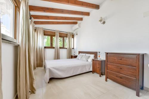 a bedroom with a bed and a dresser and a window at Villa FORTUNA - Apartamentos у Estudios para vacaciones con territorio y piscina común, Calpe in Calpe