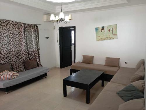 een woonkamer met een bank en een tafel bij Le petit VIP in 'Aïn el Turk