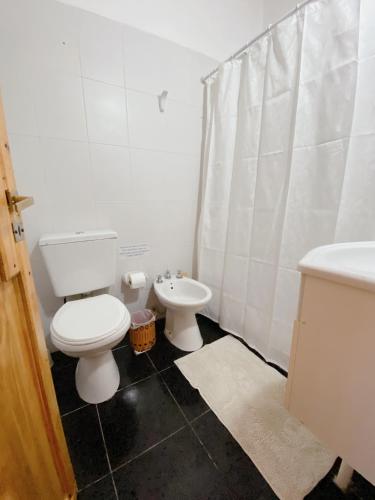 a white bathroom with a toilet and a sink at HOSPEJADE ESQUINA in Esquina