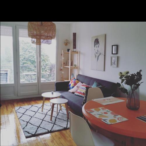 un salon avec un canapé bleu et une table dans l'établissement Parc et Parking à la Porte de Paris proche Stade de France, à Saint-Denis