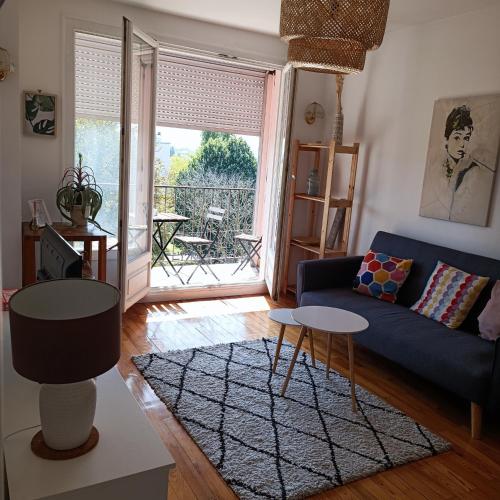 un salon avec un canapé bleu et une table dans l'établissement Parc et Parking à la Porte de Paris proche Stade de France, à Saint-Denis