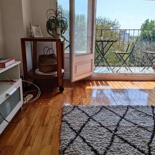 d'un salon avec une porte s'ouvrant sur un balcon. dans l'établissement Parc et Parking à la Porte de Paris proche Stade de France, à Saint-Denis