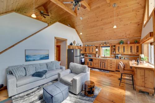 a living room with a couch and a kitchen at Catskills Cabin Rental with Hot Tub and Amazing Views! in Stamford
