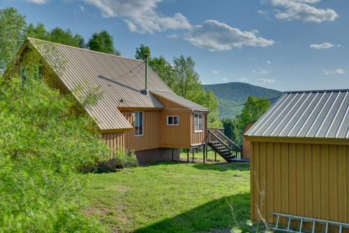 a house with a large yard next to a building at Catskills Cabin Rental with Hot Tub and Amazing Views! in Stamford