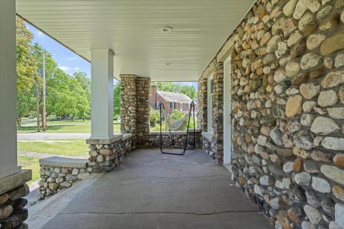 a stone building with a stone wall at 5bd Movie Theater - 7mins to UND - Backyard BBQ in South Bend