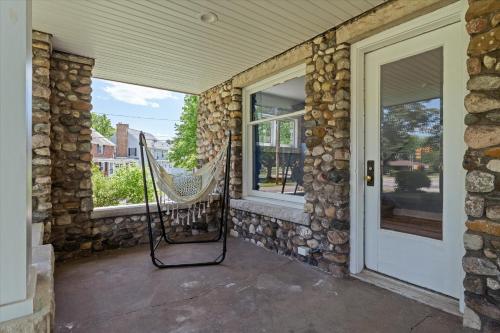 a porch with a hammock on the side of a house at 5bd Movie Theater - 7mins to UND - Backyard BBQ in South Bend