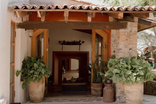 an entrance to a house with two potted plants at Hacienda San Nicolas de las Fuentes in Teuchitlán