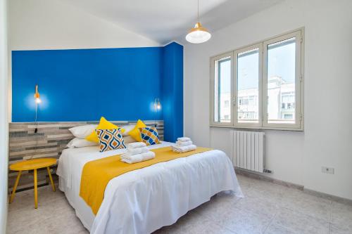 a bedroom with a large bed with a blue wall at LuEDa House - Trasfertisti e Turisti in Surbo