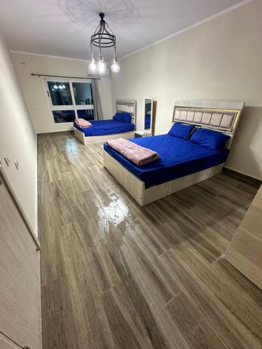 a bedroom with two beds and a wooden floor at شاليه فخم في العلمين مع اكسس على افضل شواطئ العلمين in El Alamein