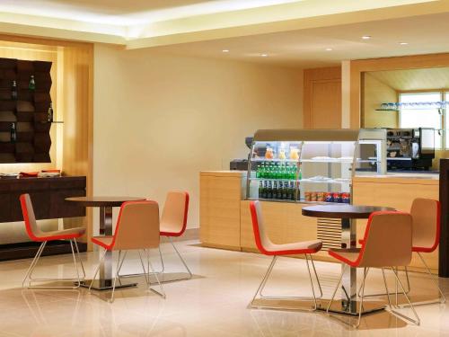 فندق إيبيس الرياض شارع العليا في الرياض: مطعم بطاولتين وكراسي وثلاجة