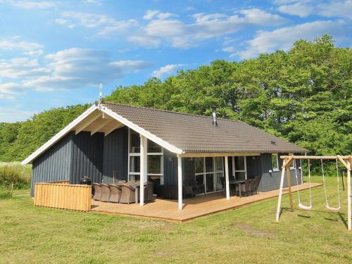a small house with a porch and a swing at 12 person holiday home in Storvorde-By Traum in Egense