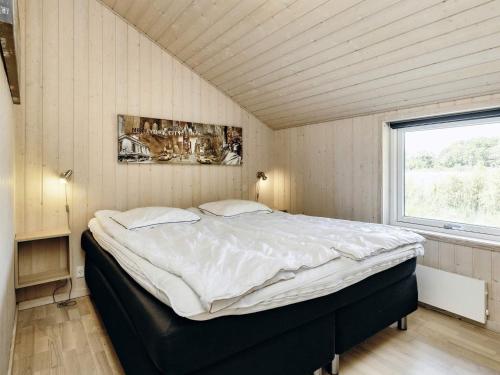 Four-Bedroom Holiday home in Storvorde في Egense: غرفة نوم بسرير كبير في غرفة مع نافذة
