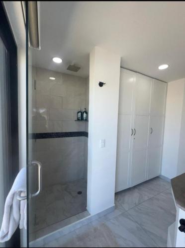 a shower with a glass door in a bathroom at Elegant Condo in an Upscale Building in Cabo San Lucas