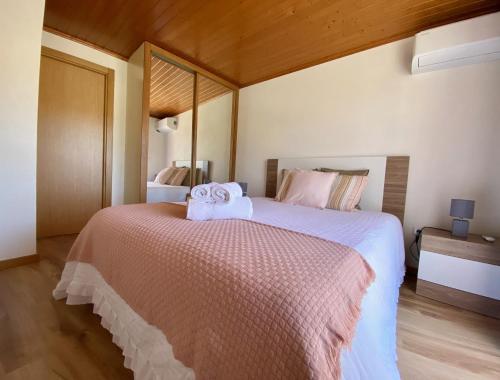 a bedroom with a large bed with towels on it at Casinha da Ti'Augusta in Lamego
