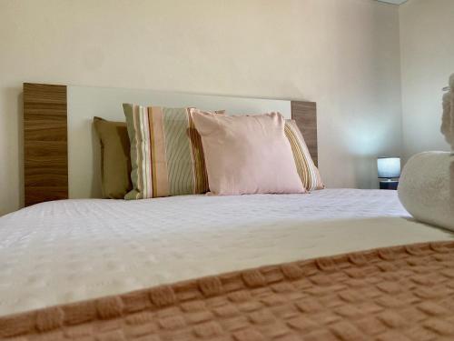 ein Schlafzimmer mit einem großen Bett mit einem rosa Kissen in der Unterkunft Casinha da Ti'Augusta in Lamego
