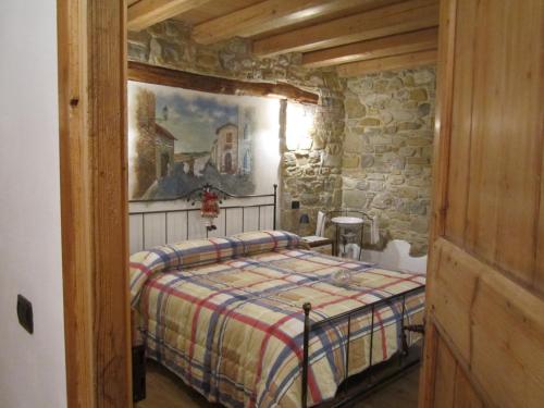 - une chambre avec un lit dans un mur en pierre dans l'établissement B&B Alla Lanterna, à Trichiana