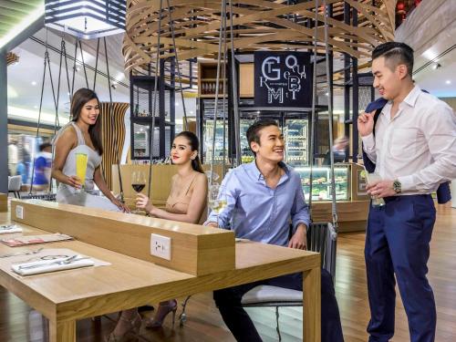 a group of people standing around a table in a store at Novotel Bangkok on Siam Square in Bangkok