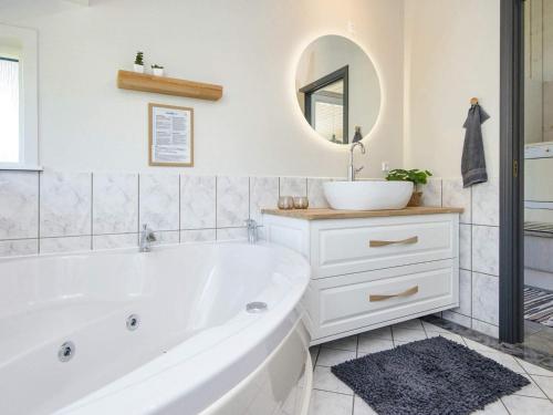 a white bathroom with a tub and a sink at Holiday home Tarm XLIV in Tarm
