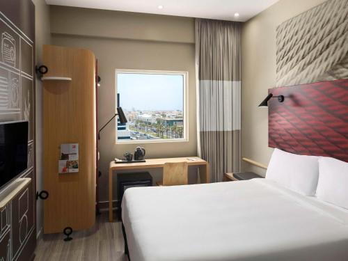 a hotel room with a bed and a window at Ibis Jeddah Malik Road in Jeddah
