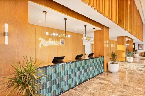 um átrio com uma área de espera com cadeiras e plantas em Radisson Blu Resort Al Hoceima em Al Hoceïma