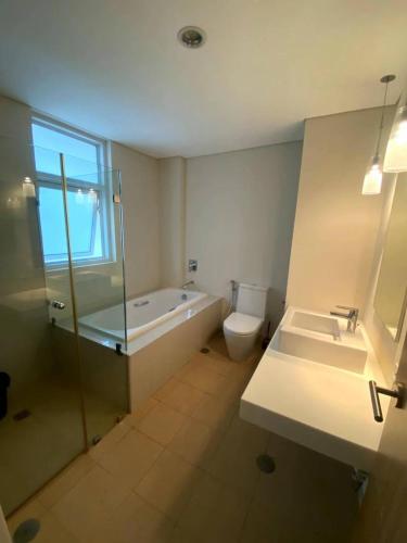 a bathroom with a tub and a toilet and a sink at Pico De Loro Room Rate in Nasugbu