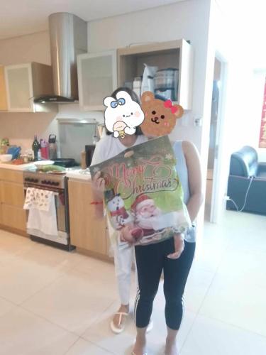 a woman is holding a book in a kitchen at Pico De Loro Room Rate in Nasugbu