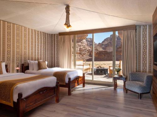 a bedroom with two beds and a view of the desert at Shaden Resort in AlUla