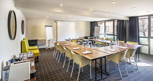 a conference room with a long table and yellow chairs at Best Western Hotel Atrium Valence in Valence