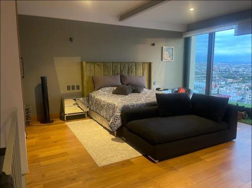 a bedroom with a bed and a couch at Depa Teo in Querétaro