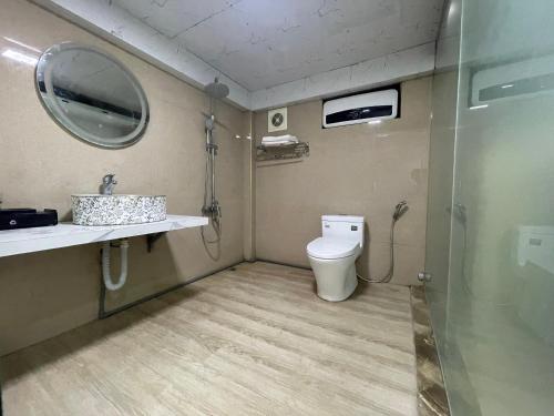 W łazience znajduje się toaleta, umywalka i lustro. w obiekcie Pina Hotel - Boutique Inn w mieście Cát Bà
