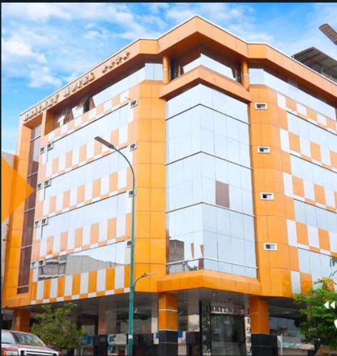 a large building with an orange and white at BRITNEY HOTEL Machala in Machala