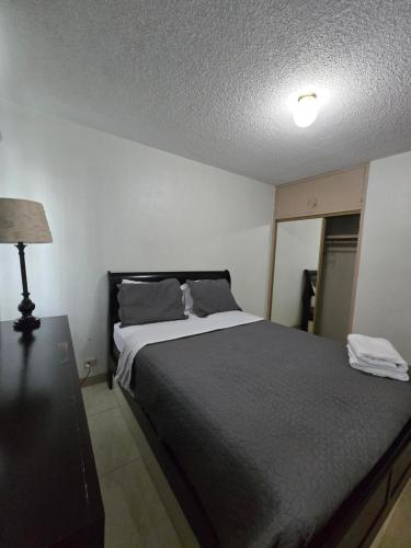 a bedroom with a bed and a table and a lamp at 2Bed1Bath - Private and Blissful Retreat in Sinajana