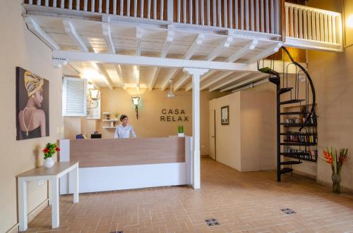 Una mujer en una oficina con mostrador de recepción. en Casa Relax Hotel, en Cartagena de Indias