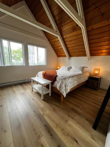 a bedroom with a bed and a wooden ceiling at Chalet Mont Sainte-Anne in Beaupré