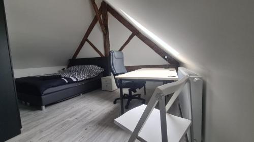 a room with a desk and a bed and a table at Appartement en duplex avec 2 chambres in Sint-Genesius-Rode