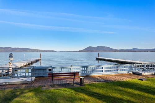 a wooden dock with a bench on the water at Skylark Shores Resort in Lakeport